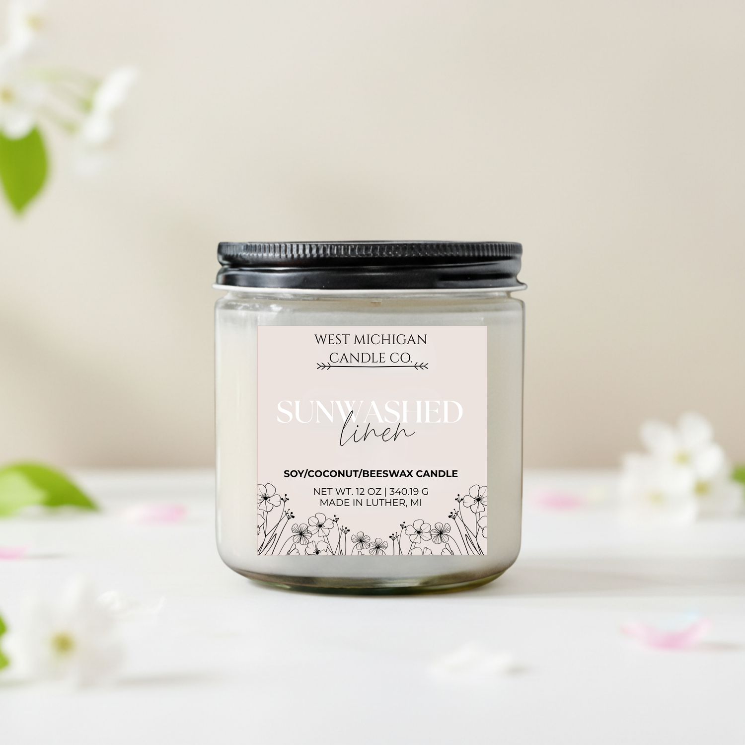 sunwashed linen candle with floral design on label against a light background